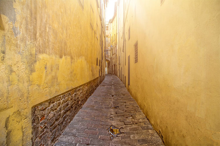 Narrow alley amidst buildings against wall