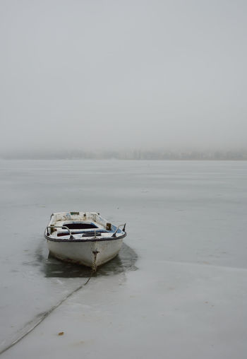 Old boat at frozen lake orestiada in kastoria,greece