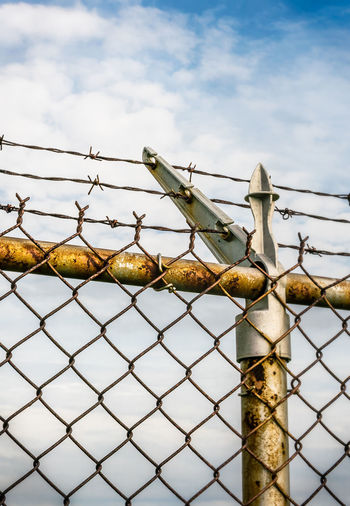 Vibrant colors, rusty chain link fence topped with barbed wire. selective focus - graphic