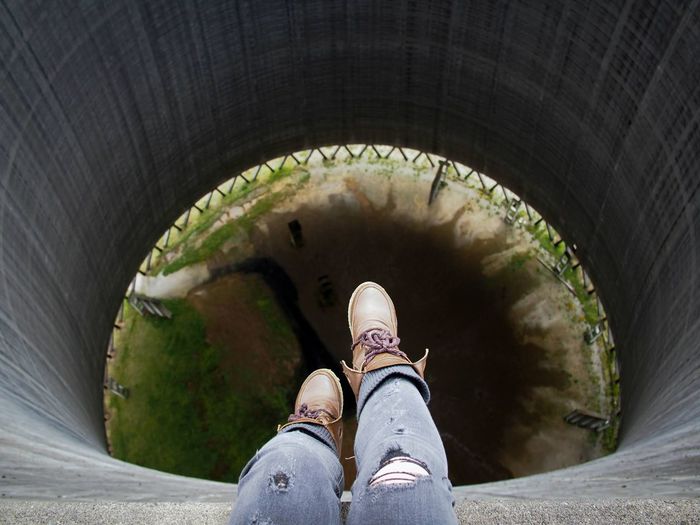 High angle view of dangling feet in an abandoned cooling tower. 