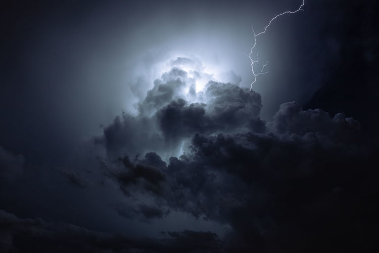 Lightning radiates through the clouds at night