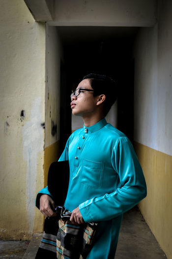 Young man standing against wall