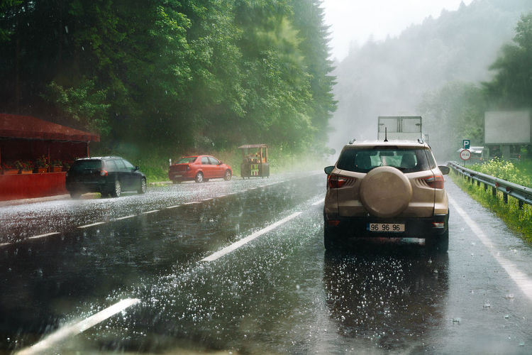 Cars on wet road during hail storm on mountain 