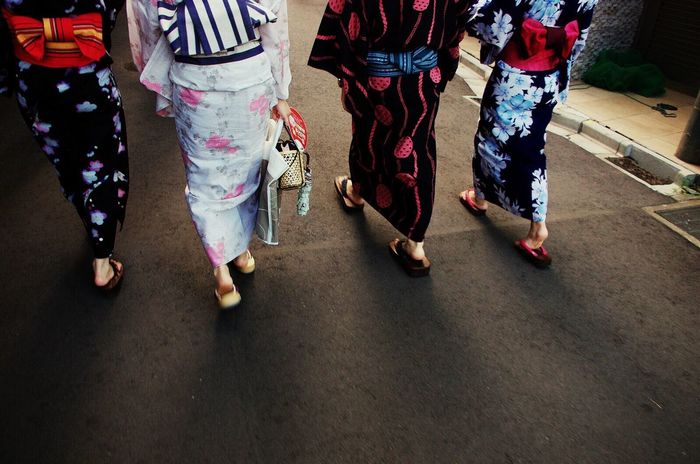 Low section of women walking on footpath