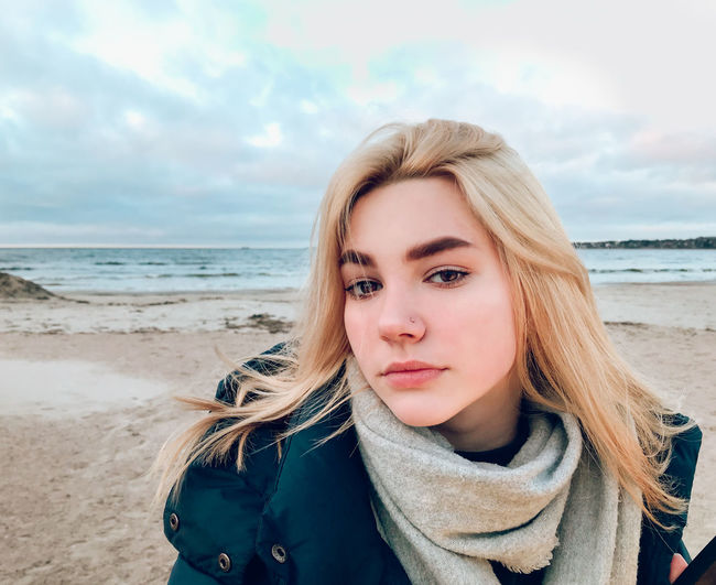 Portrait of beautiful woman on beach against sky