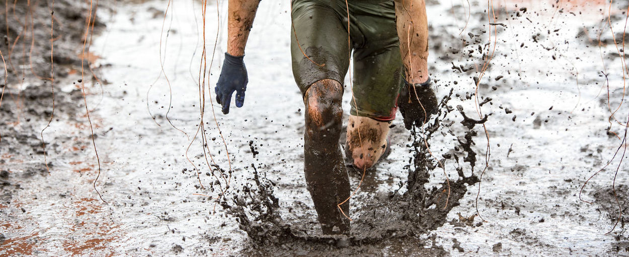 Low section of man running in mud
