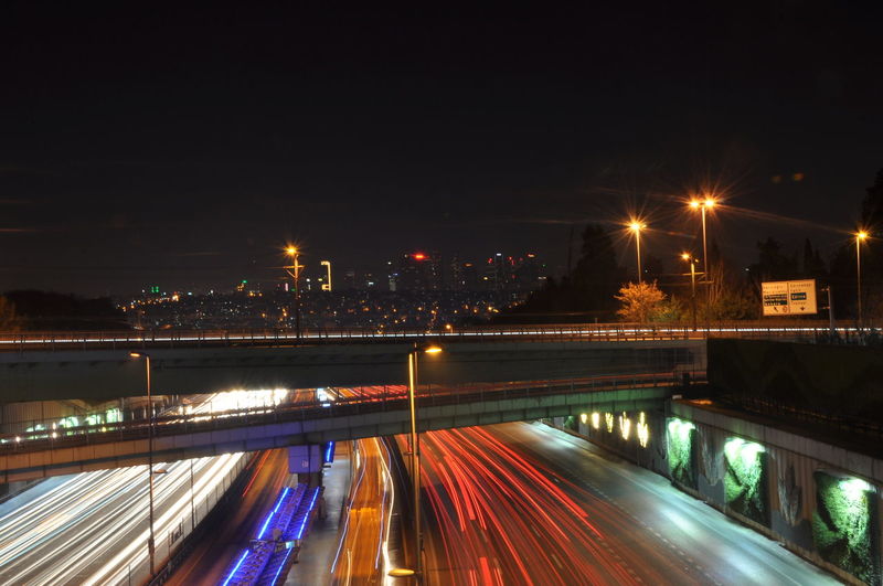 Light trails on bridge in city at night