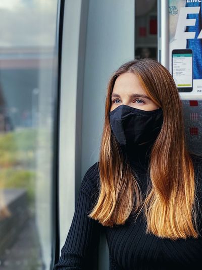 Beautiful woman wearing flu mask sitting at train