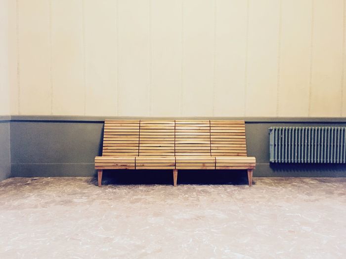 Empty bench against wall
