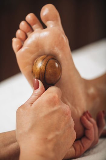 Reflexology - foot massage with rounded wooden massage tool