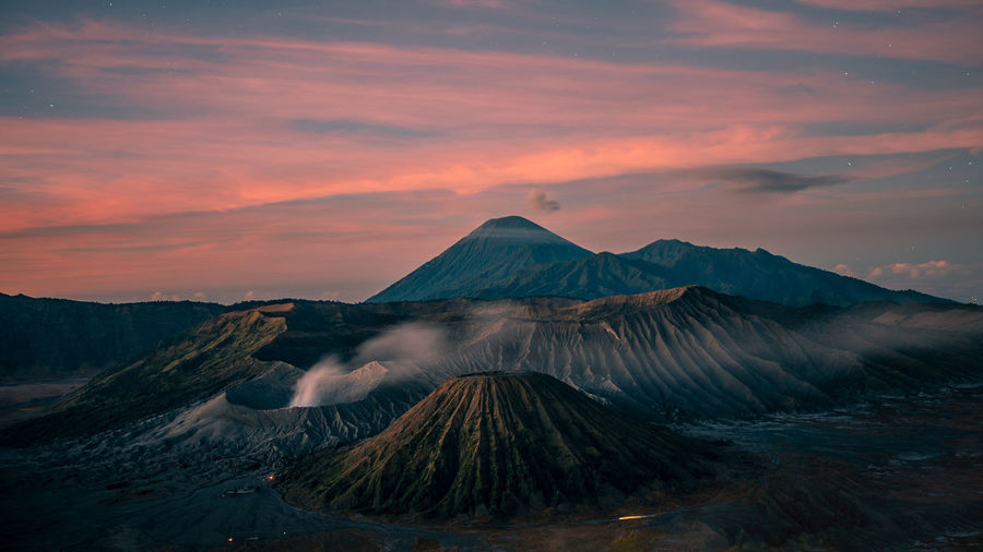 Scenic view of mountain against cloudy sky during sunset