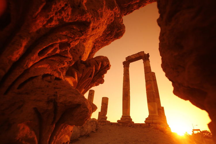 Low angle view of amman citadel seen from cave against sky during sunset