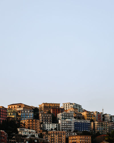 Buildings in city against clear sky