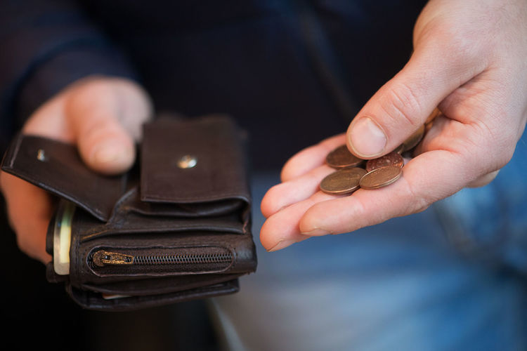 Cropped image of man holding coins and wallet