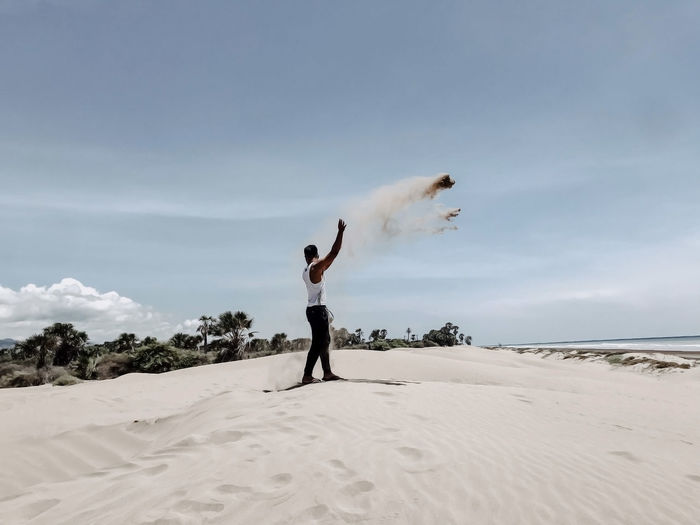 Full length of man throwing sand