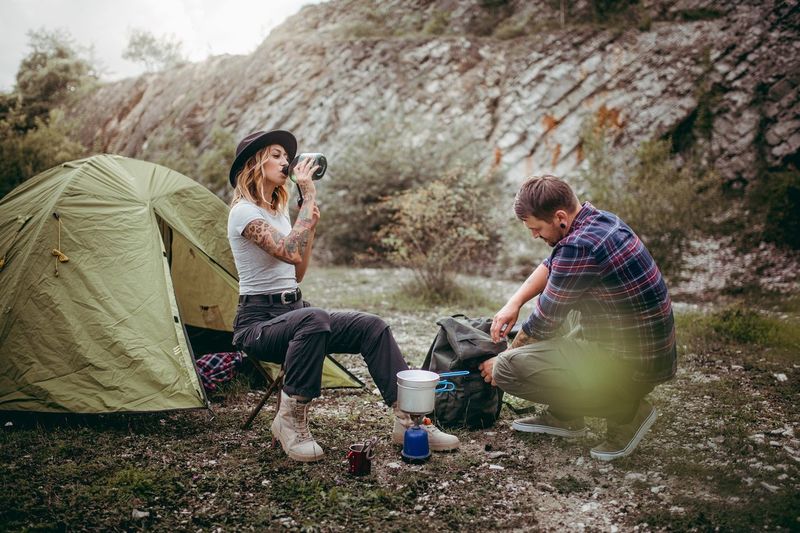Friends by tent on field