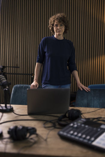 Radio dj standing by desk in recording studio
