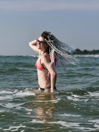 Young woman in bikini standing in sea