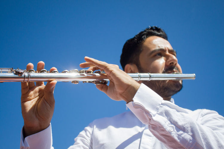 Flautist player and blue sky