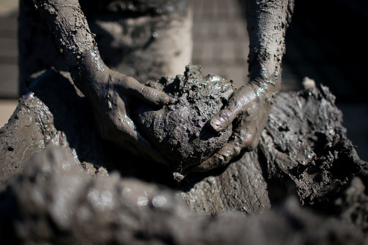 Midsection of man holing mud