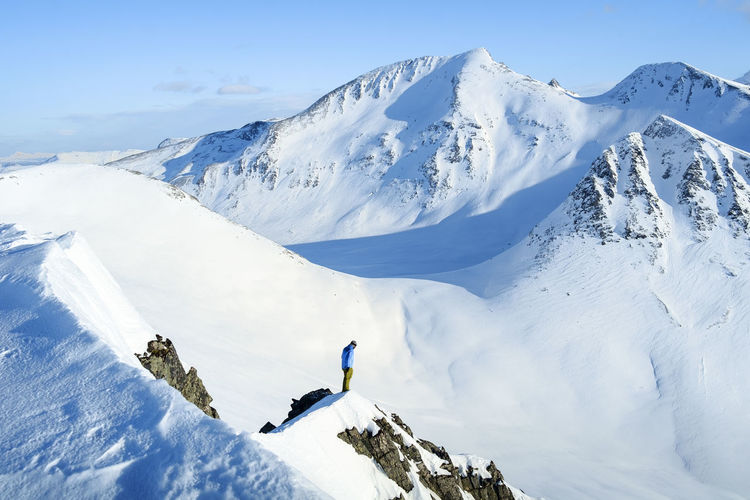 High angle view of man standing on snow covered mountain
