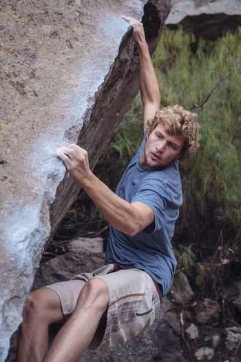 Young man climbing on rock