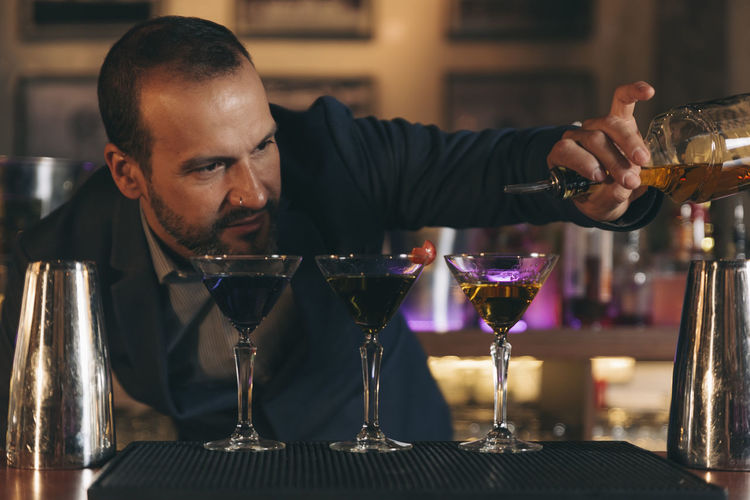 Male bartender preparing cocktail at bar counter