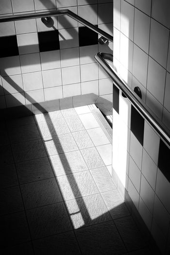 Shadow of man walking on tiled floor