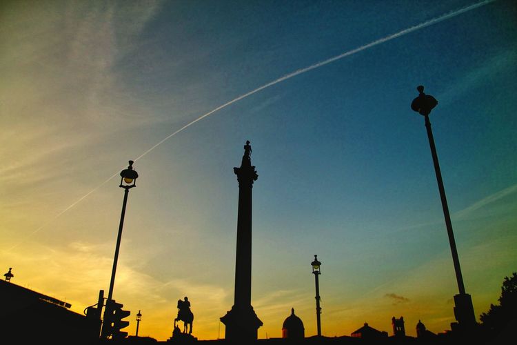 Low angle view of silhouette nelson column against sky during sunset