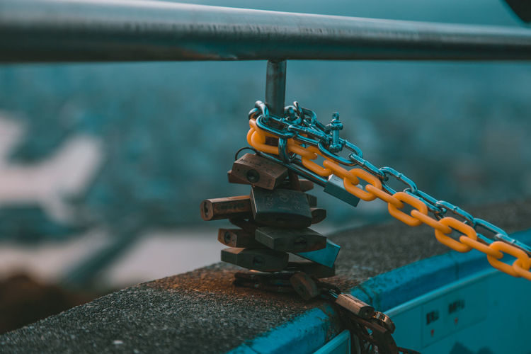 Close-up of padlocks hanging on railing