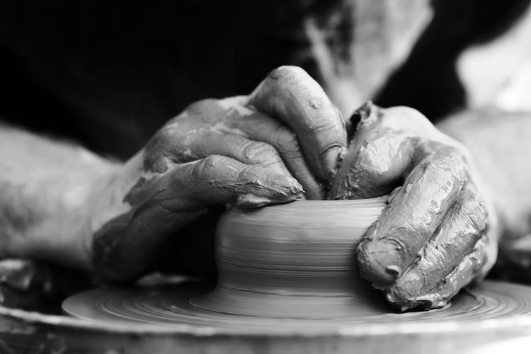 Cropped hand making pottery at workshop
