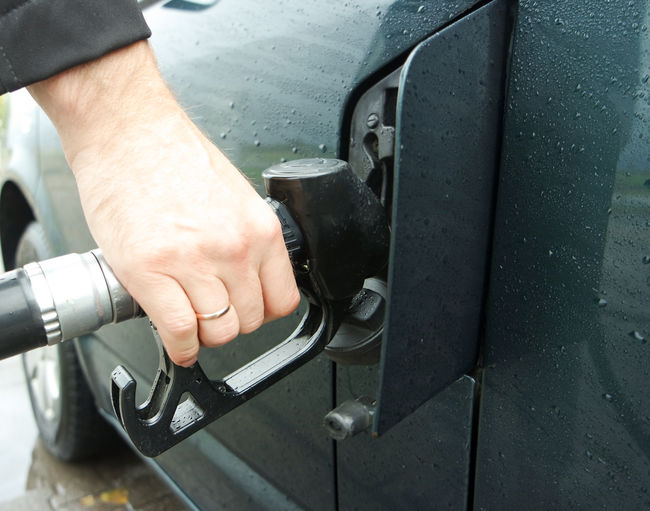 Cropped hand filling fuel in car