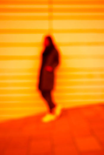 Shadow of woman walking on yellow wall