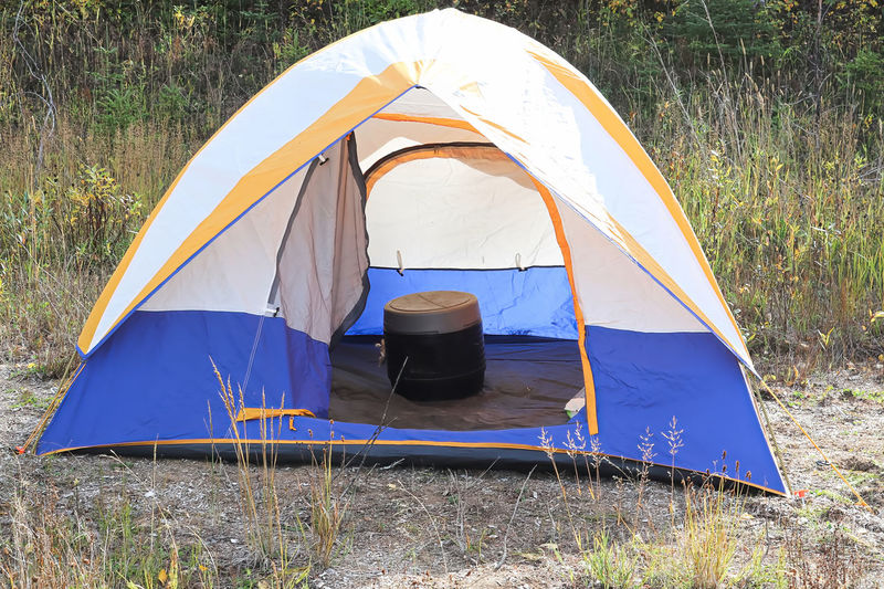 A tent with a portable chemical toilet inside it