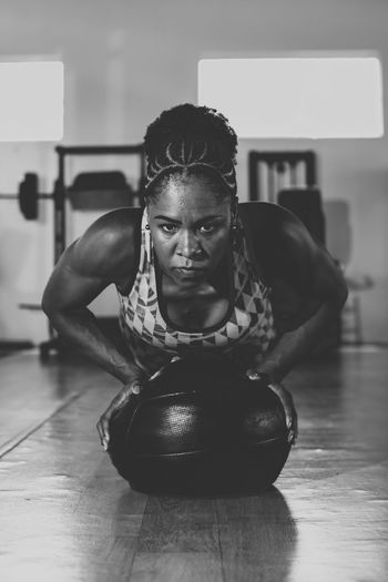 Determined woman doing support with a ball at the gym. strengthening the spine and arms.