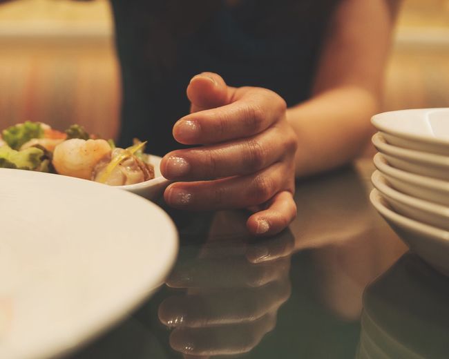 Close-up of hand holding food in plate