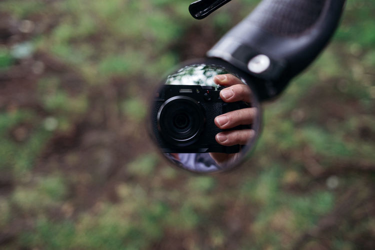 Close-up of hand holding camera outdoors