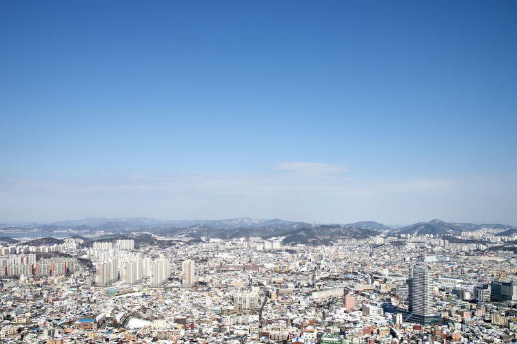 High angle view of cityscape against blue sky