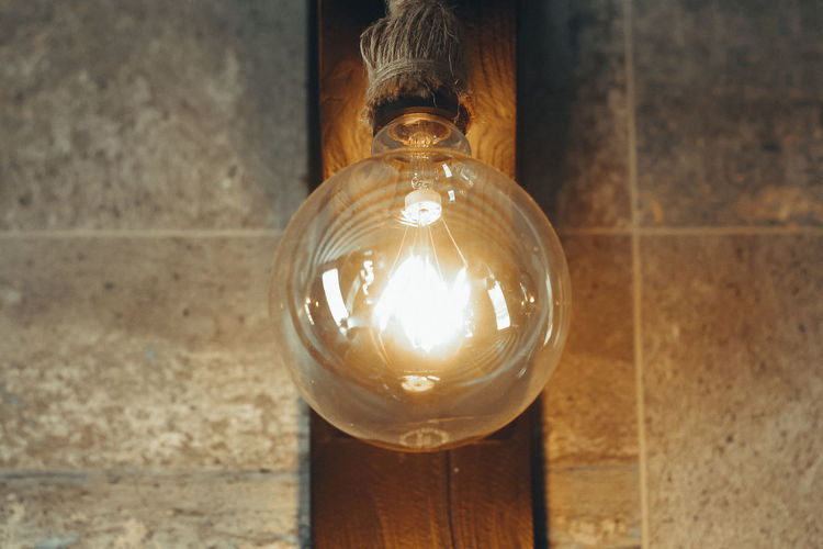 Close-up of illuminated light bulb on wall
