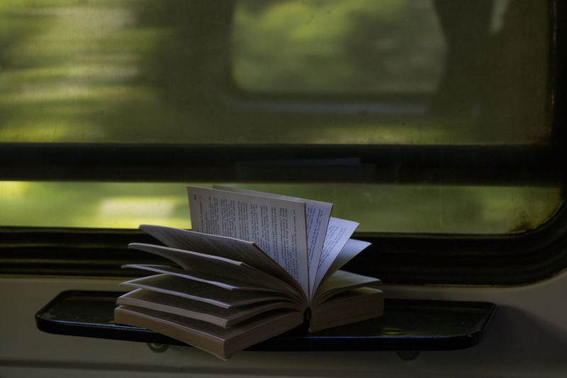 Close-up of open book on table in train
