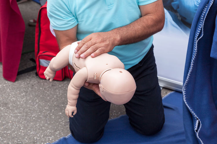 Midsection of man holding cpr dummy