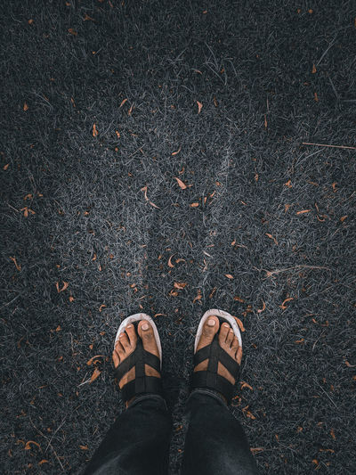 White and blue colour wearing sandals human foot standing on a lawn in kolkata 
