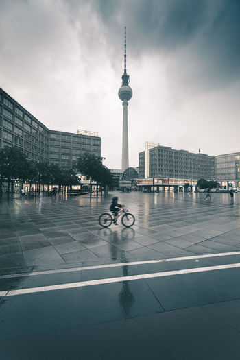 View of person riding bicycle against buildings in city