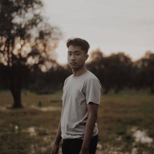 Portrait of a young man standing on field