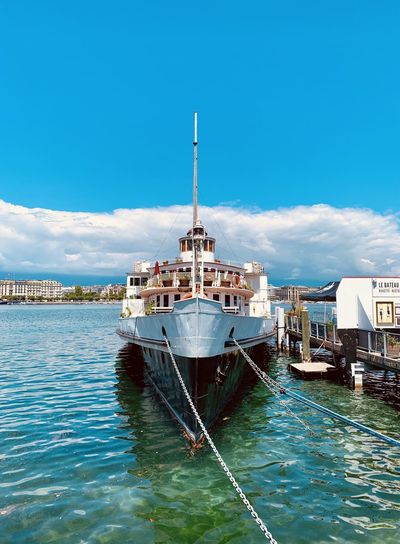 Ship moored on sea against blue sky