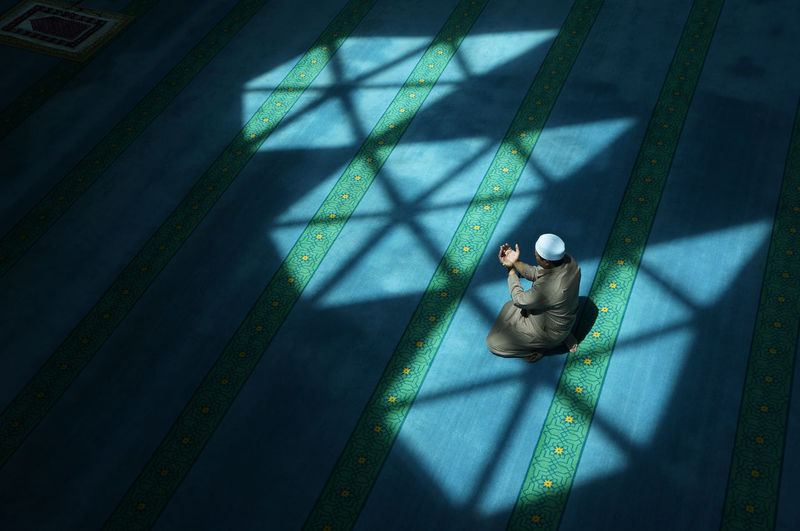 High angle view of man praying in mosque