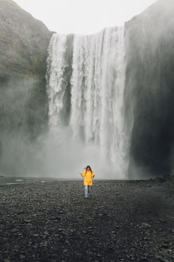 Woman standing in front of waterfall