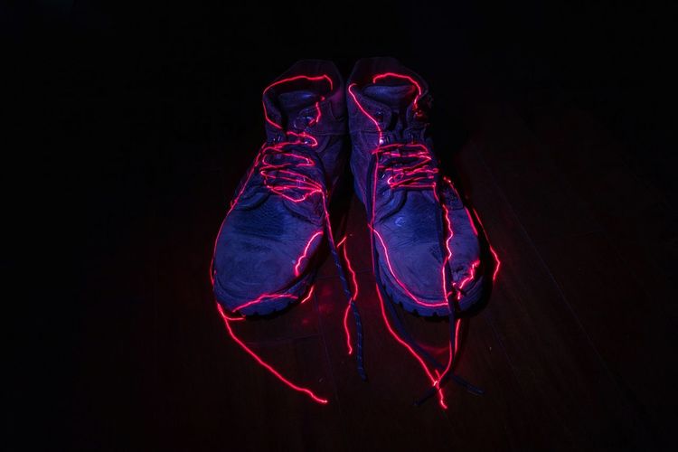 Low section of shoes over black background