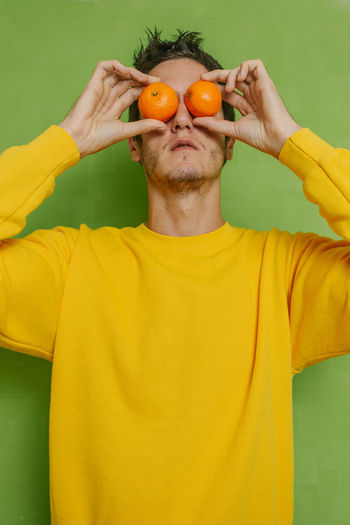 Portrait of man holding orange fruit