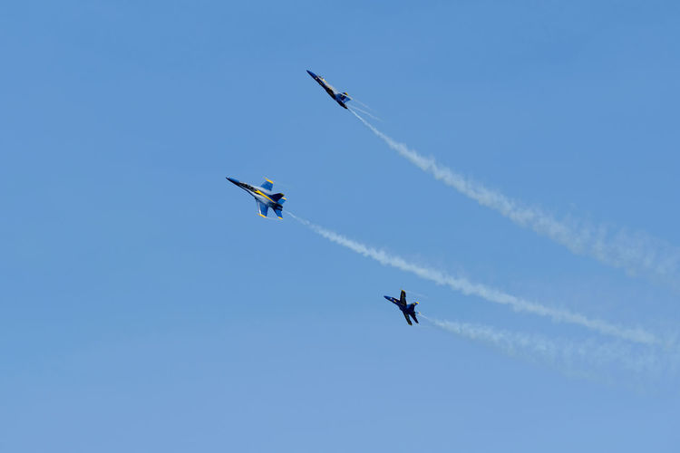Low angle view of airshow flying against sky